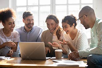 Multi-ethnic friends laughing enjoy comedy movie on computer