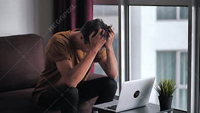 Man is unpleasantly surprised and shocked by the bad news seen on the laptop screen. Man suffers in stress and despair