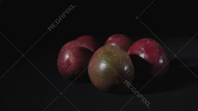Video of rotating exotic passion fruit on black background