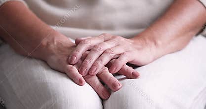 Close up view of senior woman folded wrinkled hands
