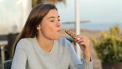 Girl eating a snack in a coffee shop in slow motion