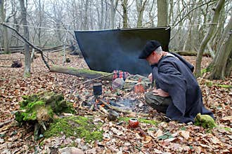 Senior active man camping in woods with yerba drink