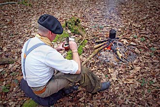 Senior active man camping in woods with yerba drink