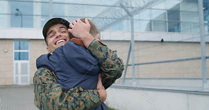 Son with USA flag running into father soldier embrace.