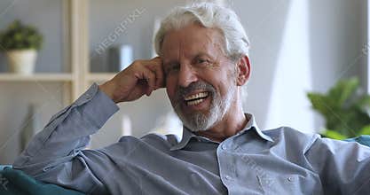 Thoughtful older man looking at camera, hearing good news.