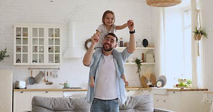 Smiling young daddy carrying excited little daughter, dancing together.