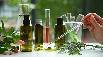 Scientist dropping organic natural essence in petri dish, Alternative green herbal extract medicine.