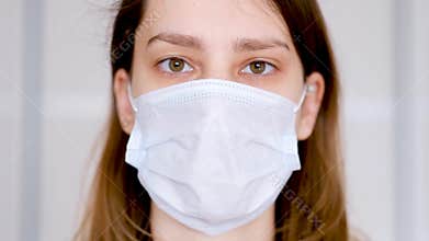 Close-up of a young woman wearing a protective medical mask, coronavirus