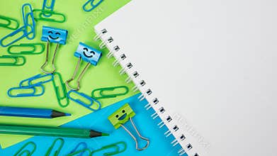 Office Paper Clip, Smile Binder Clips and Pencils on Notepad