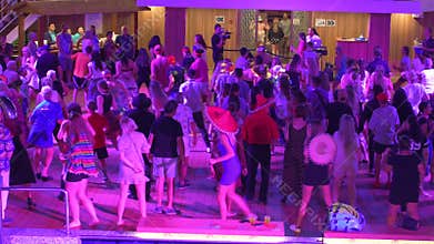 People singing and dancing to YMCA on a cruise ship. Includes audio.