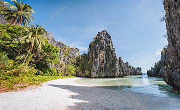 Empty hidden beach in morning sun light at El Nido, Palawan, Philippines. Holiday vacation destination