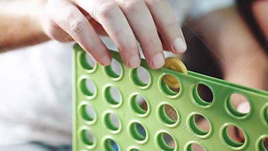 Closeup hands of people playing in `Connect four` game in the pub