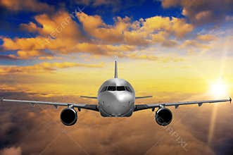 Airplane on sunset sky