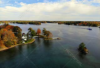 The aerial view of the waterfront residential area surrounded by striking fall foliage by St Lawrence River of Wellesley Island,