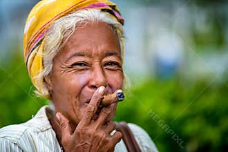Authentic elderly Cuban woman smoking cigar. Beautiful senior woman enjoying cigar, Santiago de Cuba