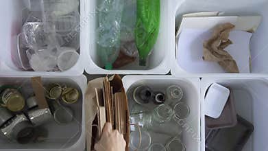 Young woman is putting different garbage in containers for recycling at home interior. Spbd