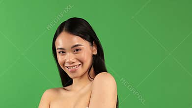 Close up of an Asian woman who shows off her clear skin by touching the fingers of her skin and breasts. The concept of