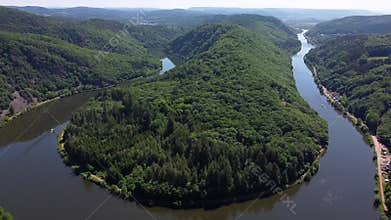 Descending aerial shot of saar loop river in Germany during sunny day
