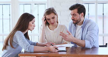 Angry young clients dissatisfied with purchase contract details.