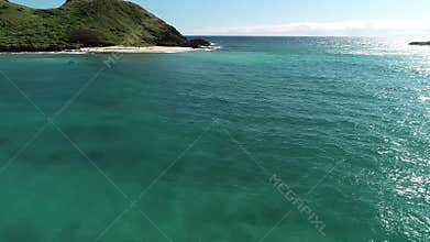 Honolulu, Hawaii, low angle view with drone camera moving forward, luscious green island in open waters, color graded