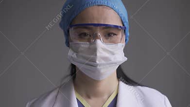 Asian doctor looking at the camera wearing goglass and pollution mask.