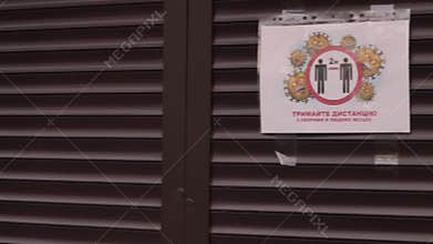 Warning announcements about quarantine and self isolation on the wall of a closed shop at empty park