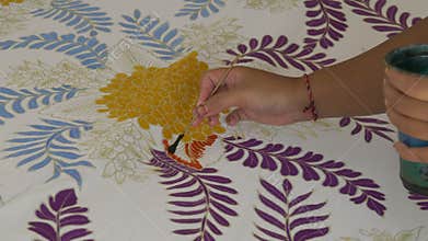 GIANYAR, INDONESIA - JUNE, 19, 2017: close up of a worker painting batik cloth in bali