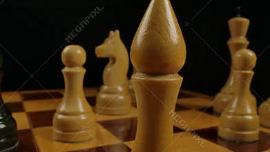 Men`s hand puts a bishop figure on checkerboard cell