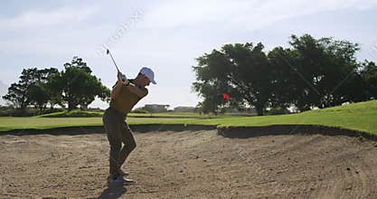Golf player hitting the ball with his club