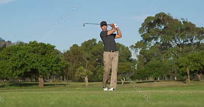Golf player hitting the ball with his club