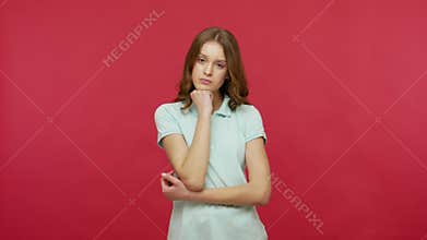 Disinterested upset young woman in polo t-shirt looking with bored indifferent e