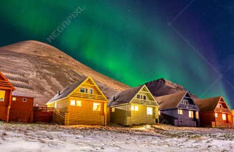 Longyearbyen colorful houses with Aurora Borealis in the sky full of stars