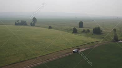 Aerial view truck carries freshly cut feed crop to farm on country road across field. Farmers will use plants for animal