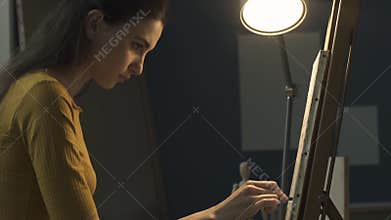 Young artist sketching on the canvas with charcoal