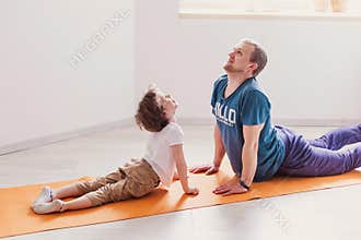 Dad son do sport at home. The father teaches child a healthy lifestyle. Parenthood