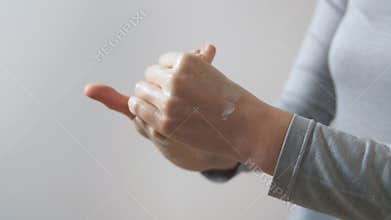 Close up of woman applying moisturizing hand cream