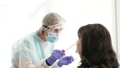 Medical staff member with protective mask and gloves taking nasal swabs to elderly woman.