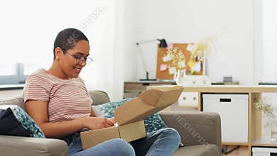 African american woman opening parcel box at home