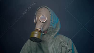 Man in gas mask and protective suit dancing in the smoke