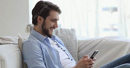 Smiling man enjoying communicating in social network on phone.