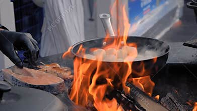 Slow motion: chef cooking scallop meat, salmon, prawn - close up