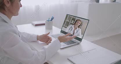 Young intern physician woman is calling by video chat to experienced female doctor to consulting, talking and asking