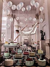 Man flying with balloons above cakes portrait beauty portrait photoshoot