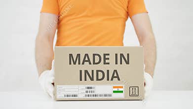 Man puts cardboard box with MADE IN INDIA text on the table