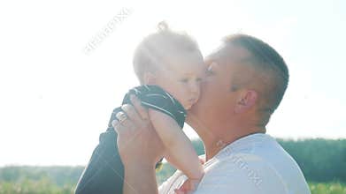 Dad kiss holds the baby son in his arms playing in the park. father day kid dream childhood happy family concept. parent