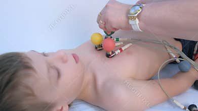 Doctor cardiologist preparing child boy to cardiogram heart procedure, closeup.