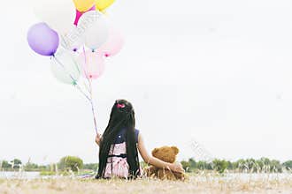 Happy Child hug teddy bear hold air balloon in green park playground. Teddy bear best friend for little kids cute girl. Autism