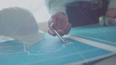 Architect and Engineer in a team discussing house drawings, closeups pointing to a drawing