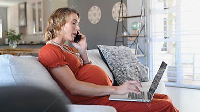 Pregnant woman working at home with laptop