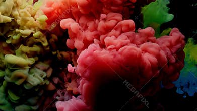 Colorful rainbow paint drops from above mixing in water. Ink swirling underwater.